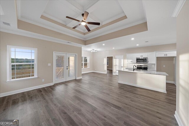 unfurnished living room featuring crown molding, a raised ceiling, light hardwood / wood-style flooring, and ceiling fan