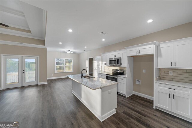 kitchen with white cabinetry, stainless steel appliances, a center island with sink, and sink