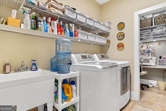 washroom with light tile patterned floors, sink, and washer and clothes dryer