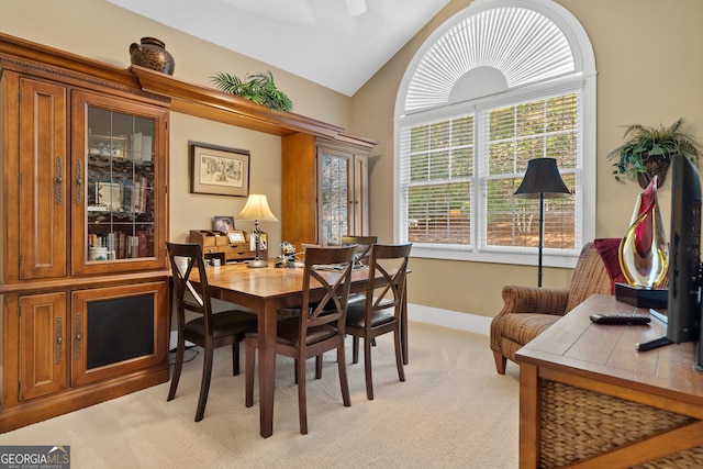 carpeted dining area featuring lofted ceiling