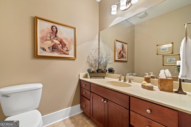 bathroom with toilet, vanity, and tile patterned flooring