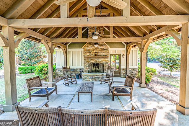 view of patio featuring a gazebo, ceiling fan, and an outdoor stone fireplace