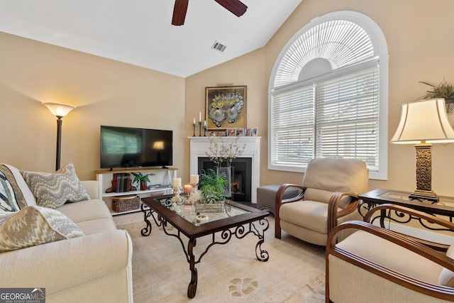 living room featuring a wealth of natural light, ceiling fan, and vaulted ceiling