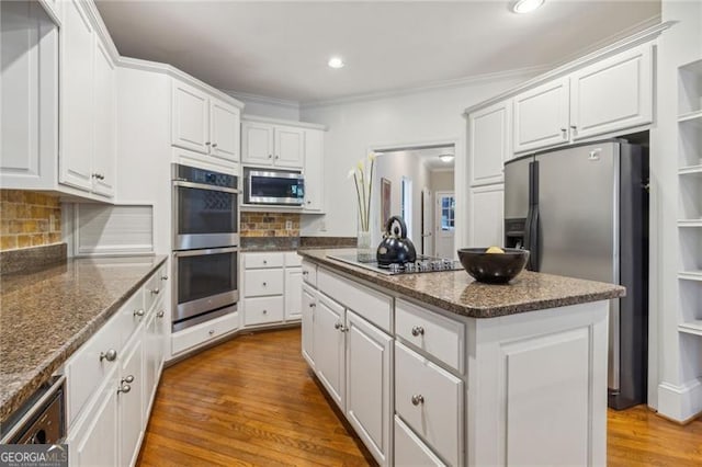 kitchen with a kitchen island, light hardwood / wood-style floors, white cabinetry, and appliances with stainless steel finishes