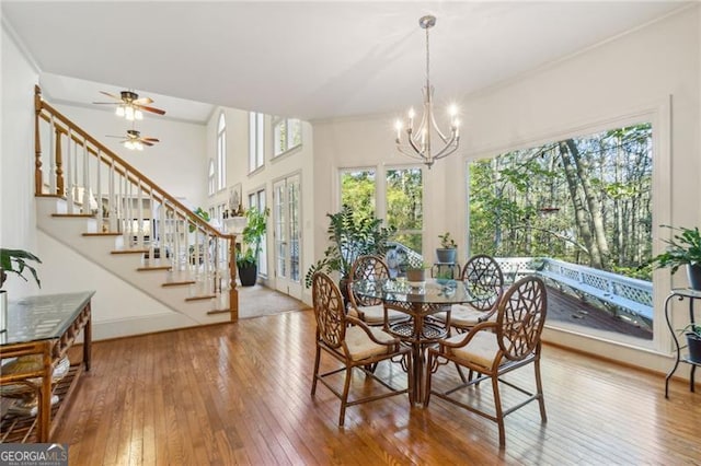 dining space featuring hardwood / wood-style floors, ceiling fan with notable chandelier, and crown molding