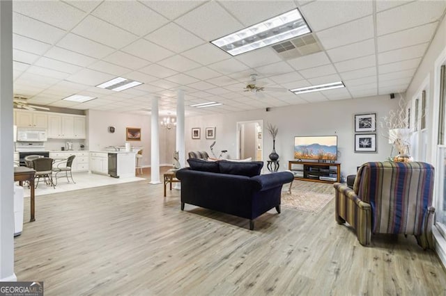 living room featuring a drop ceiling, light hardwood / wood-style floors, and ceiling fan with notable chandelier