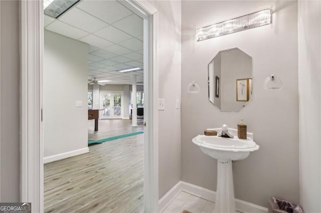 bathroom with a paneled ceiling, ceiling fan, and hardwood / wood-style floors