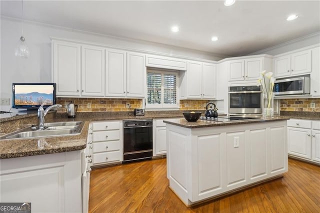 kitchen with sink, a center island, black appliances, and light hardwood / wood-style flooring