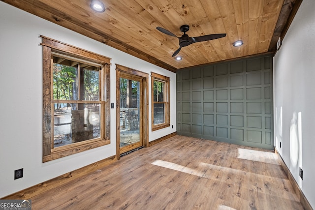 empty room with light hardwood / wood-style flooring, ceiling fan, and wood ceiling