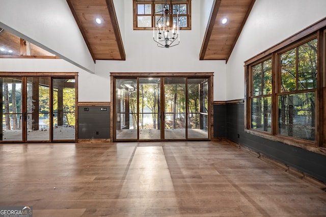 doorway to outside with high vaulted ceiling, hardwood / wood-style floors, wooden ceiling, and a chandelier