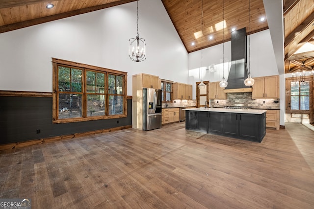 kitchen with hanging light fixtures, a notable chandelier, stainless steel appliances, wooden ceiling, and a kitchen island with sink