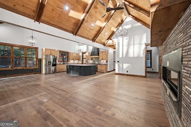 unfurnished living room featuring a notable chandelier, high vaulted ceiling, and wood ceiling