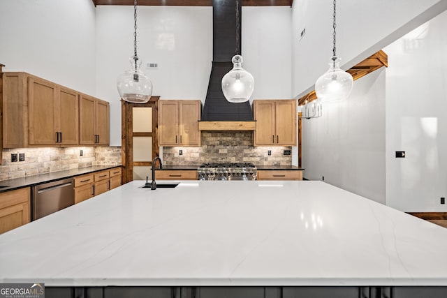 kitchen featuring a large island with sink, stove, hanging light fixtures, and dishwasher