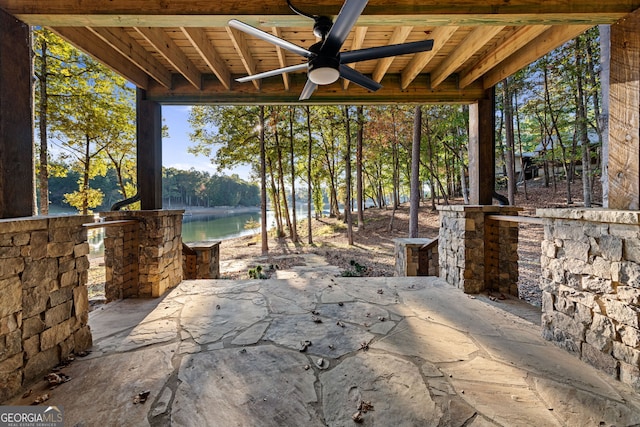 view of patio with a water view and ceiling fan