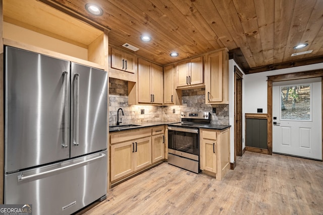 kitchen featuring appliances with stainless steel finishes, light hardwood / wood-style floors, backsplash, light brown cabinets, and sink