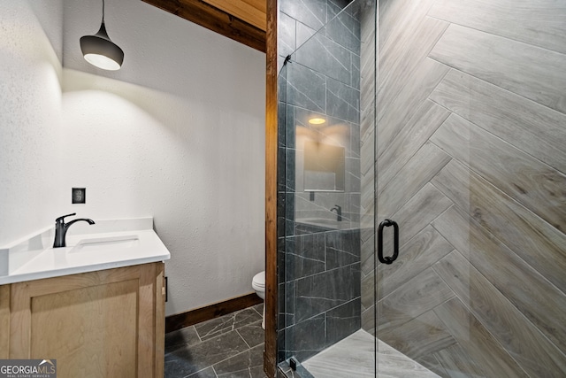 bathroom with toilet, vanity, and a shower with door