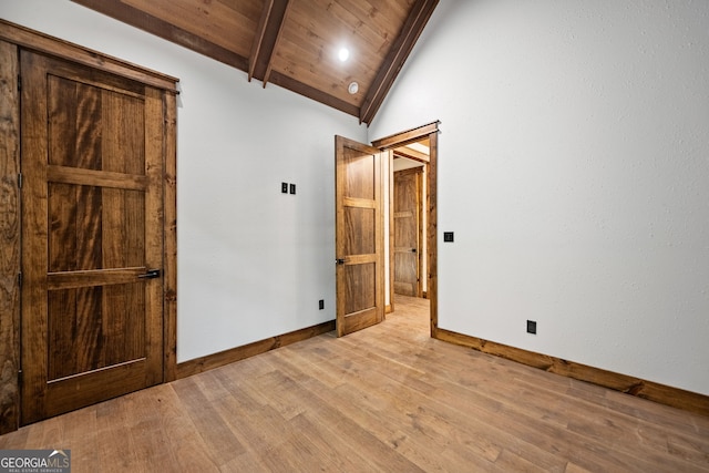 unfurnished bedroom featuring light wood-type flooring, wooden ceiling, and lofted ceiling with beams