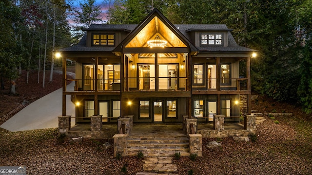 rear view of property with a patio area, french doors, and a balcony