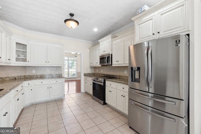 kitchen featuring appliances with stainless steel finishes, white cabinets, and stone countertops