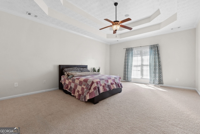 bedroom with carpet floors, ornamental molding, ceiling fan, and a raised ceiling