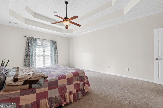 bedroom featuring carpet, ceiling fan, a raised ceiling, and a textured ceiling