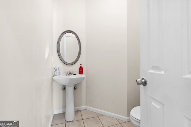 bathroom with toilet and tile patterned flooring