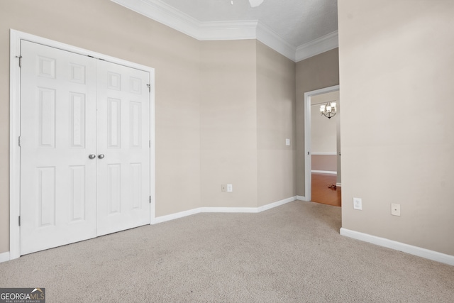 unfurnished bedroom with crown molding, a notable chandelier, and carpet