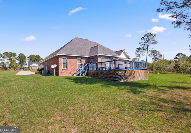 back of property featuring central AC, a wooden deck, and a lawn