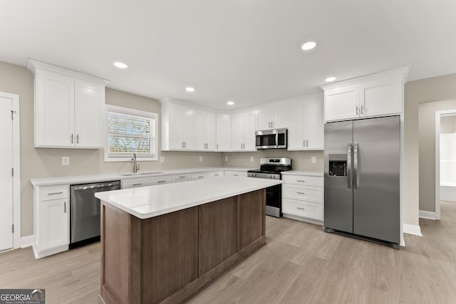 kitchen with white cabinetry, sink, a center island, light hardwood / wood-style flooring, and appliances with stainless steel finishes