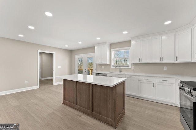 kitchen with white cabinets, a kitchen island, sink, and appliances with stainless steel finishes