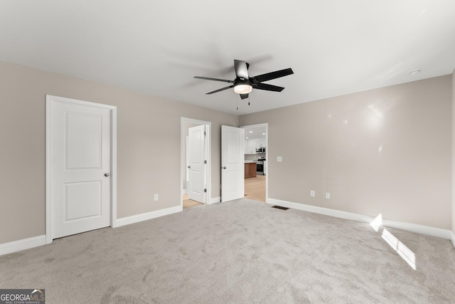 unfurnished bedroom with ceiling fan and light colored carpet