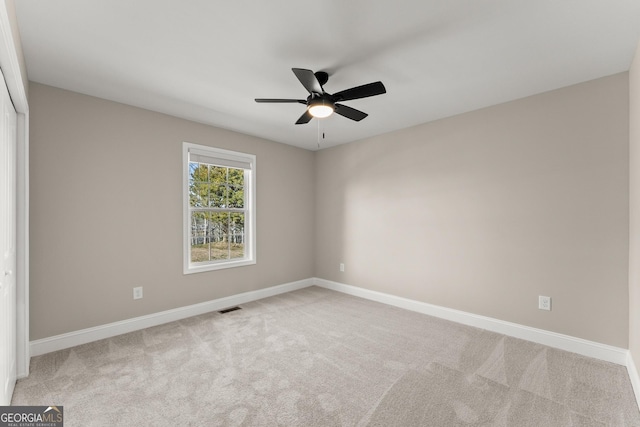 carpeted spare room with ceiling fan