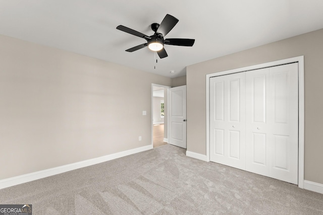 unfurnished bedroom with light carpet, a closet, and ceiling fan