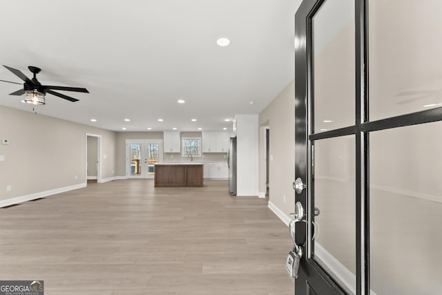 unfurnished living room with light hardwood / wood-style flooring and ceiling fan