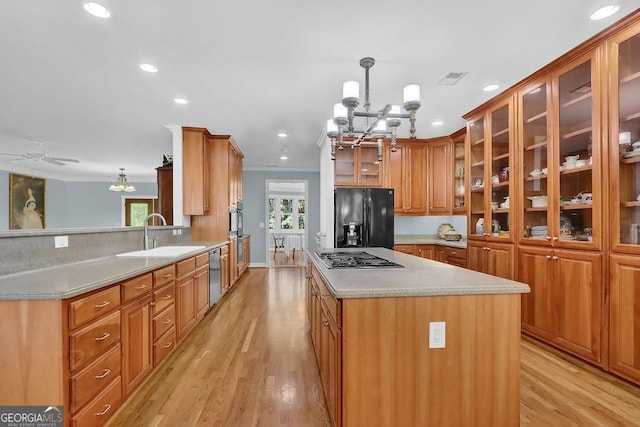 kitchen featuring decorative light fixtures, sink, light hardwood / wood-style flooring, and stainless steel appliances