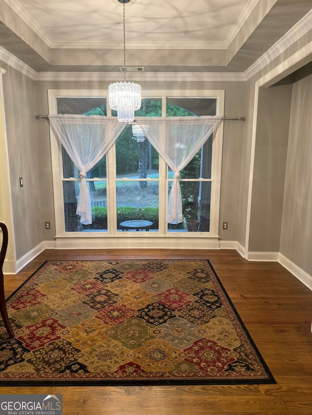 interior details featuring ornamental molding, a notable chandelier, hardwood / wood-style floors, and a tray ceiling