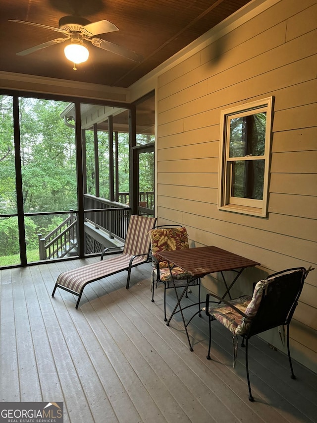 sunroom featuring ceiling fan and wood ceiling