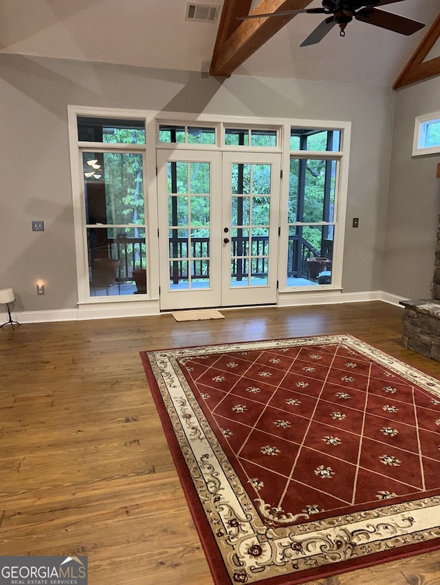 interior space featuring french doors, lofted ceiling with beams, wood-type flooring, and plenty of natural light