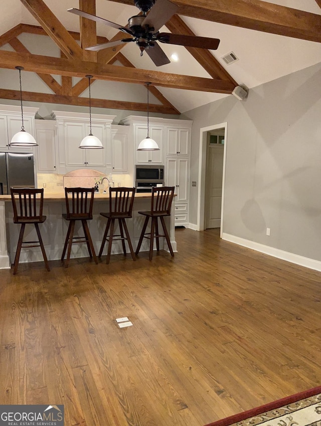 dining space featuring beam ceiling, ceiling fan, dark hardwood / wood-style flooring, high vaulted ceiling, and sink