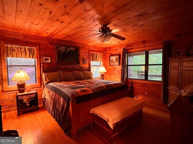 bedroom with wooden ceiling, light hardwood / wood-style floors, ceiling fan, and wooden walls