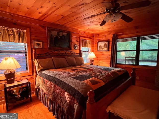 bedroom with light wood-type flooring, wood walls, and wooden ceiling