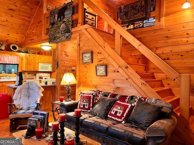 living room with wood walls, wooden ceiling, sink, hardwood / wood-style floors, and lofted ceiling