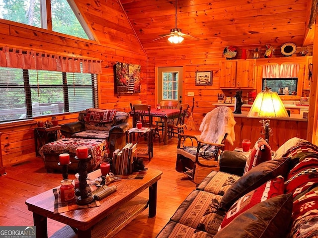 living room with high vaulted ceiling, wood walls, wood ceiling, ceiling fan, and light hardwood / wood-style flooring