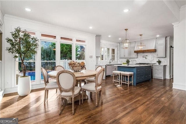 dining area with crown molding, sink, and dark hardwood / wood-style floors