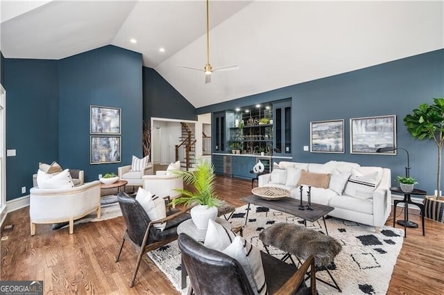 living room featuring hardwood / wood-style flooring, ceiling fan, and vaulted ceiling