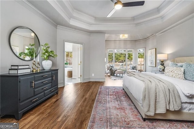 bedroom featuring ornamental molding, dark wood-type flooring, a raised ceiling, and ceiling fan