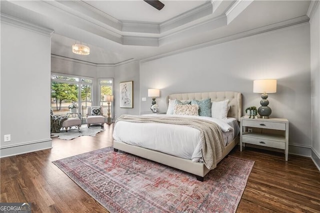 bedroom with ornamental molding, dark hardwood / wood-style floors, and a tray ceiling