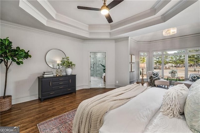 bedroom with crown molding, dark hardwood / wood-style floors, a tray ceiling, and ceiling fan