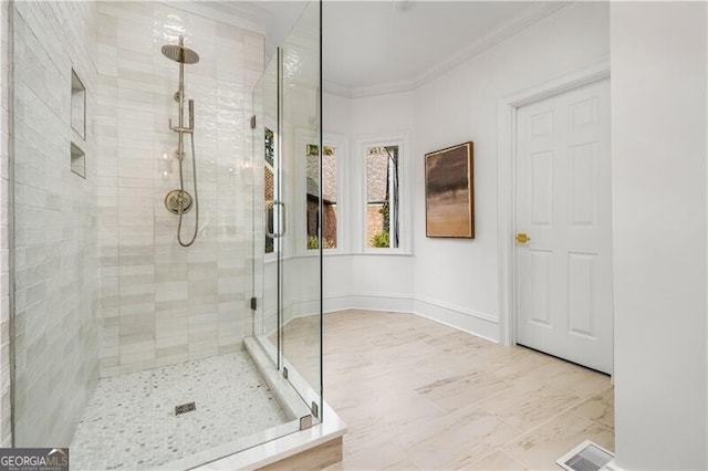 bathroom with crown molding and walk in shower