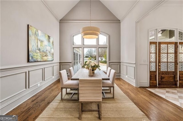 dining room featuring vaulted ceiling, ornamental molding, and light hardwood / wood-style flooring